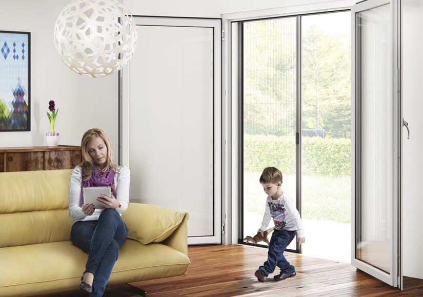 Niño caminando en la sala de estar a través de la mosquiteros Brezza